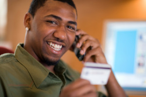 Man using credit card and cell phone